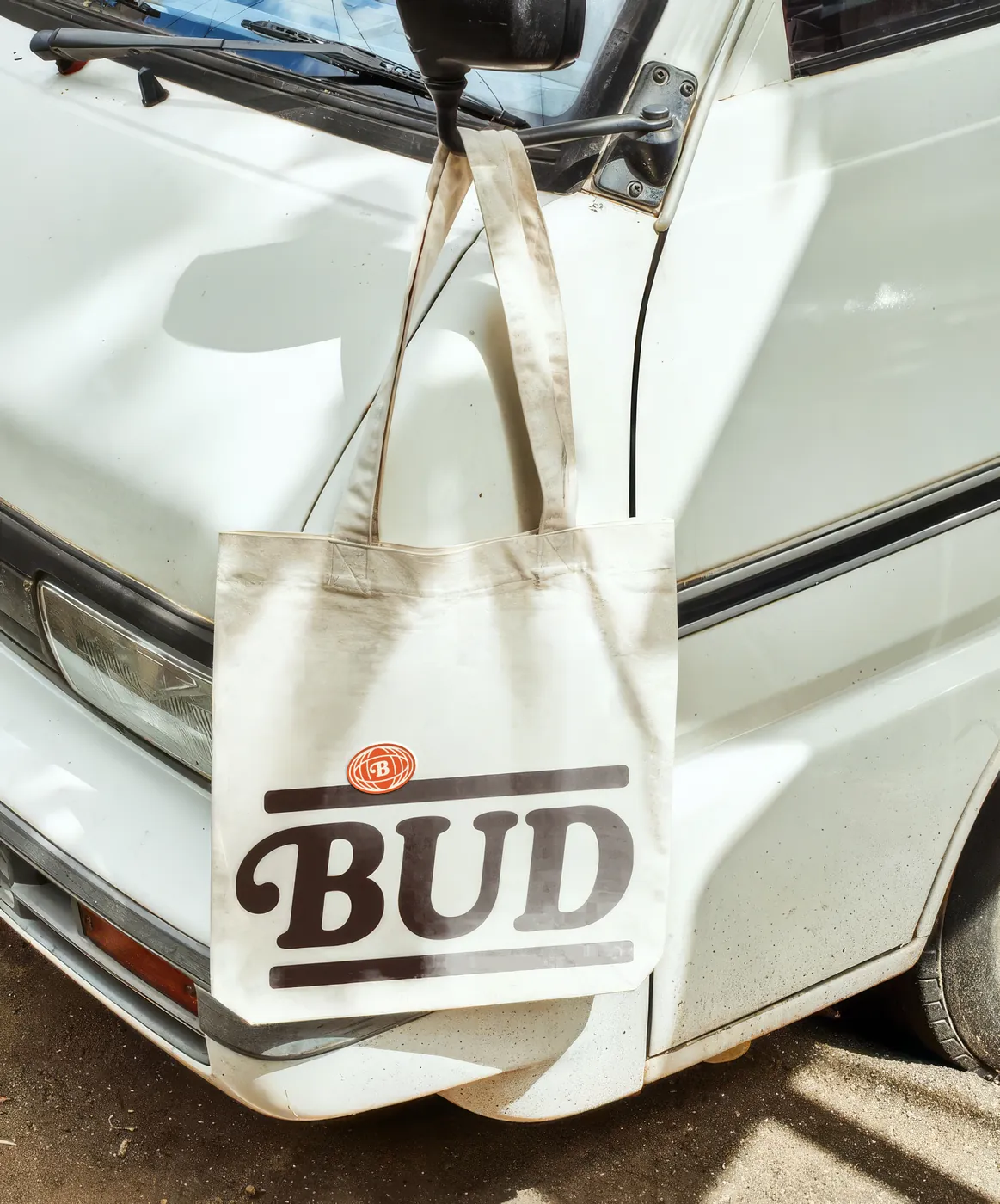 Ecobag Bud pendurada no retrovisor de uma van
